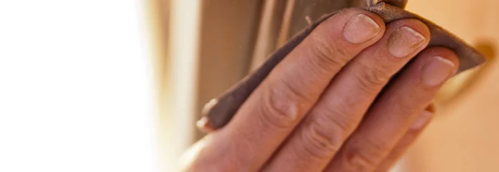 Hand schleift Holz mit Schleifpapier